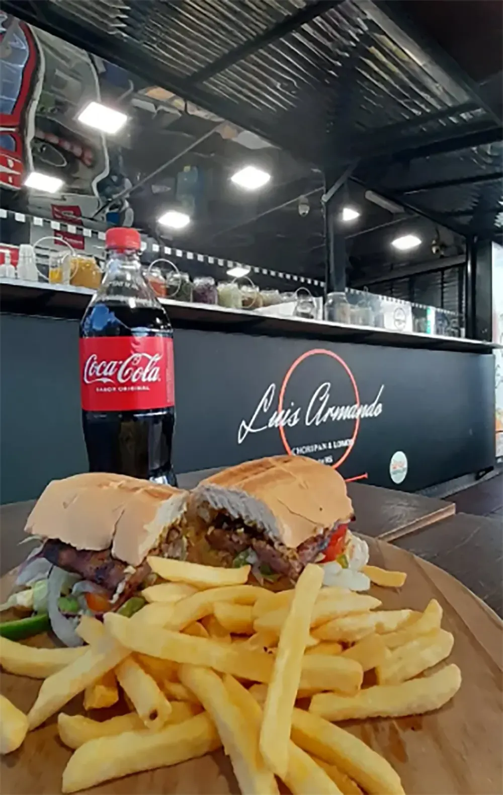 Choripán con papas fritas y gaseosa en el carro